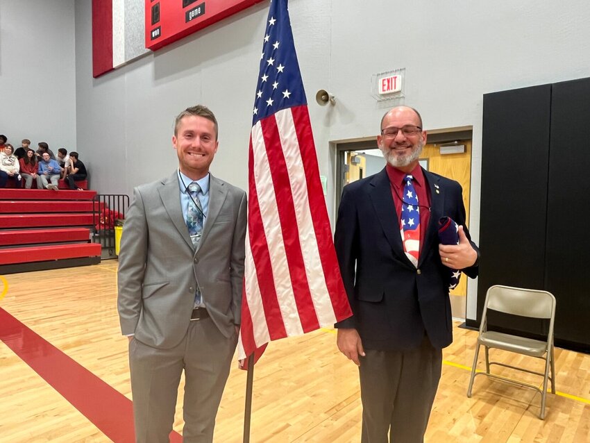 Warrensburg Middle School teachers Creighton Collier, left, and Dan Plets pose for a photo with the American flag after the Veterans Day assembly on Friday, Nov. 10 at Warrensburg Middle School. Plets, an Air Force veteran, was the keynote speaker.
