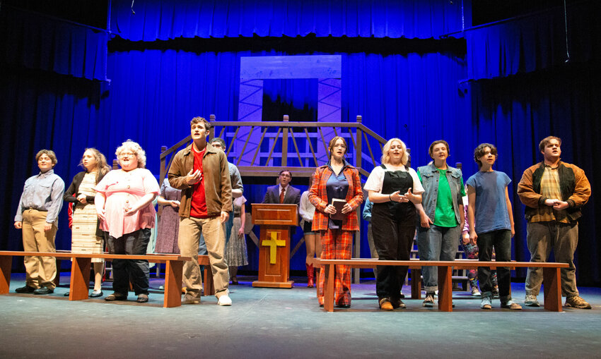 Citizens in the town of Bomont sing while at church, with Ren McCormack (Anthony Rehn), in red, being the new kid in town during a dress rehearsal of &ldquo;Footloose&rdquo; on Monday evening, Nov. 13 at Warrensburg High School.   Photo by Nicole Cooke | Star-Journal
