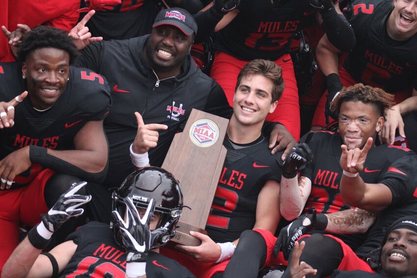 Central Missouri redshirt junior quarterback Zach Zebrowski and teammates pose for a photo with the Mules&rsquo; MIAA Championship trophy onNov. 4, at Walton Stadium.