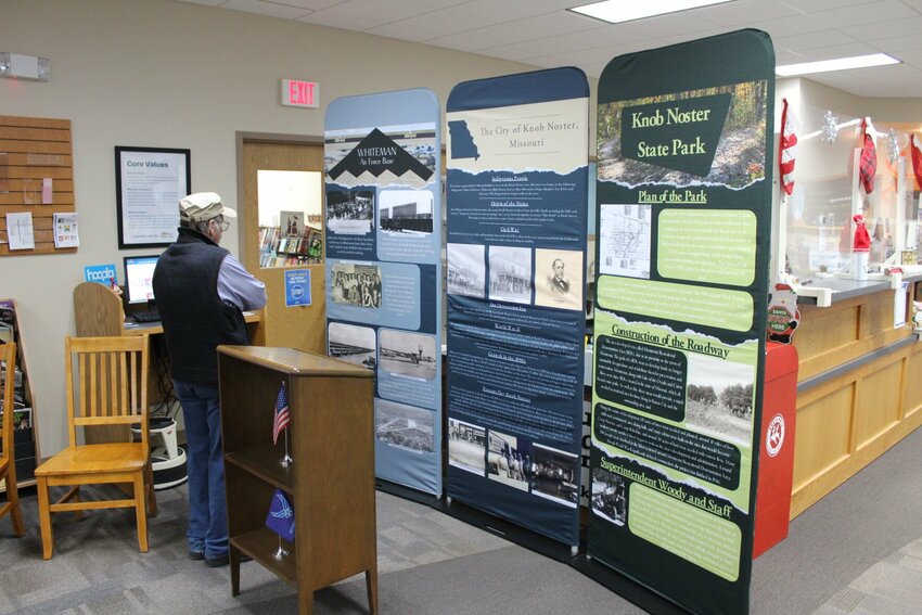 A guest at the VIP opening for &ldquo;Crossroads: Change in Rural America&rdquo; admires the Whiteman Air Force Base exhibit on Saturday, Dec. 16, at the Trails Regional Library Knob Noster Branch. All three exhibits - based on the history of Knob Noster, Knob Noster State Park, and Whiteman - will remain at the Trails Regional Library once Crossroads departs.