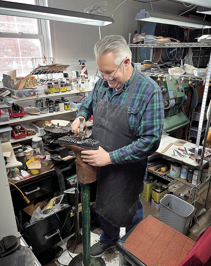 Thursday morning, Jan. 11, Eduard Dudkin demonstrates how he resoles a boot in his shop, Master Shoe Repair, 420B S. Osage Ave. Eduard and his wife, Maryna Dudkina, opened the full-service shop in March 2022.   Photo by Faith Bemiss-McKinney | Sedalia Democrat
