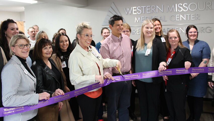Western Missouri Medical Center President and CEO Darinda Dick, center, smiles toward the camera and prepares to cut the ceremonial ribbon on Monday, March 25, at Heart Care of Warrensburg. 
