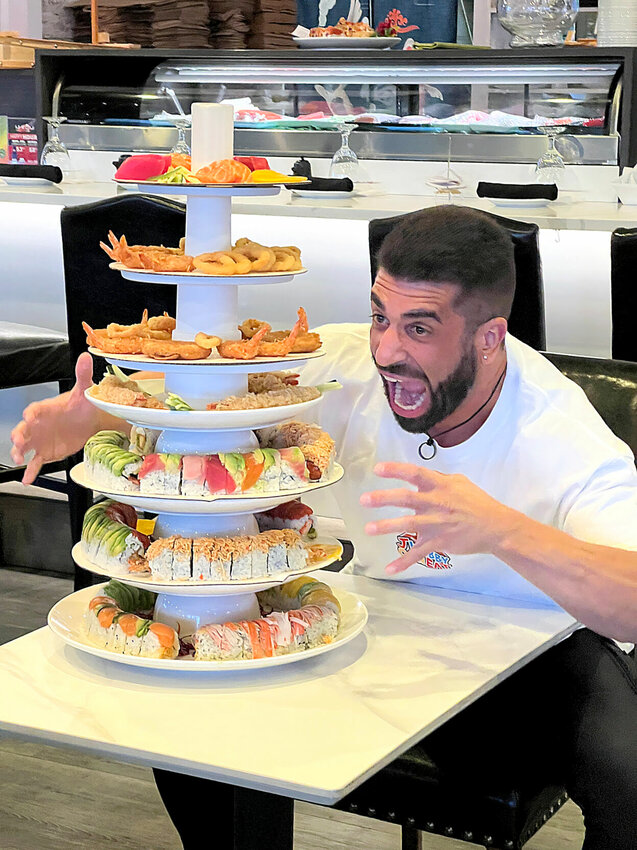 Thursday, March 28, competitive eater JWebby (James Webb), of Sydney, Australia, hams it up before polishing off a seven-layer 
