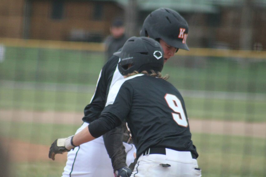 Knob Noster sophomore Oliver Defenbaugh and junior Trent Gallagher celebrate runs scored against Lafayette County on Tuesday, April 2, at the Knob Noster Sports Complex.