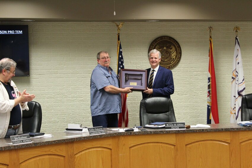 Now-Warrensburg Mayor Bruce Uhler presents former mayor Jim Kushner with a mayoral plaque for his two years of service during the Warrensburg City Council meeting on Monday, April 8, at the Warrensburg Municipal Court.