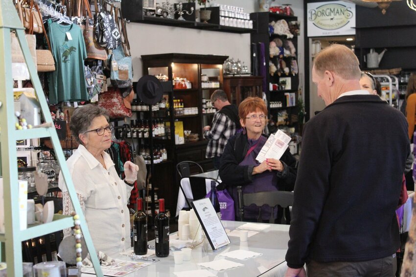 A representative from Phantom V Distilling Company LLC of Warrensburg and a stroll participant discuss their wine tastebuds on Saturday, April 20, at MKI Pavilion. 