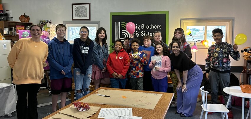 Johnson County United Way Director Rachel Mifflin, end of first row, poses for a photo with Big Brothers Big Sisters representatives after presenting a grant in March.   Photo courtesy of Big Brothers Big Sisters