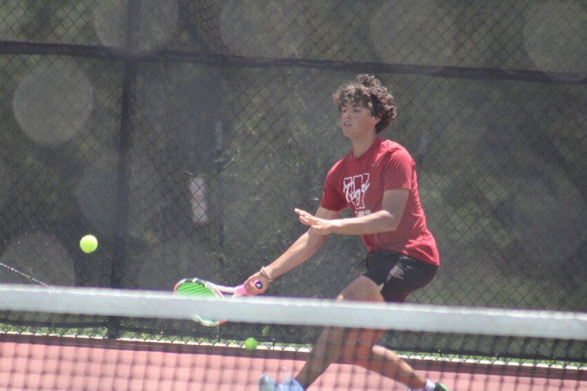 Warrensburg boys tennis junior Liam Hynes finishes an attack againt Webb City during the Class 2 District 7 semifinal round Tuesday, May 7, at the Warrensburg Activities Complex.