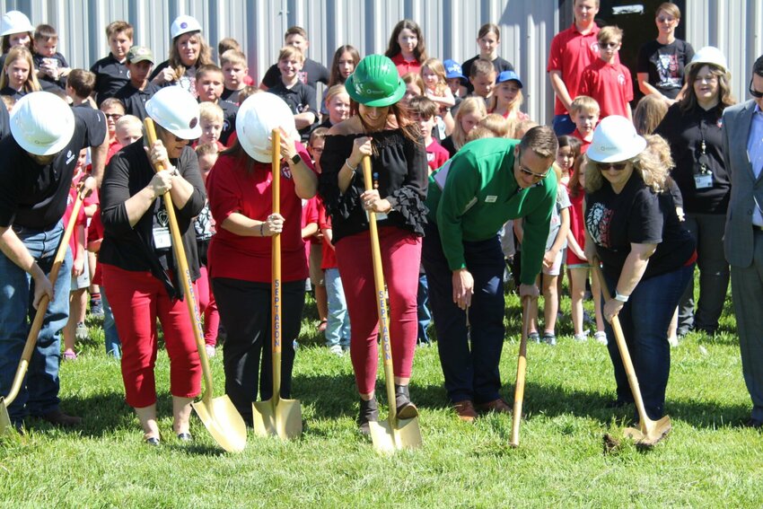 Warrensburg Christian School Director Liz Fatka, center with green hard hat, members of the school and Septagon Construction workers dig into the ground, beginning the school's expansion&nbsp;on Thursday, May 9.&nbsp;Phase 1 of the expansion will add on four new classrooms to the private school.&nbsp;