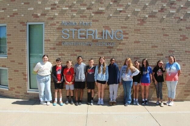 Maggie Burgin, Warrensburg Main Street Event and Marketing Coordinator, stands outside Sterling Elementary with students from Mrs. Maduros and Mrs. Stewart&rsquo;s fifth grade classes and social worker Katie Quinn after the Movie on the Lawn Committee meeting.   Photo courtesy of Warrensburg Main Street