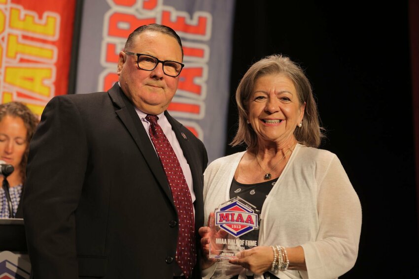 MIAA Commissioner Mike Racy presents Vici Hughes, the wife of the late Jerry Hughes, with a MIAA Hall of Fame plaque during the MIAA Awards Ceremony Celebration on Monday, June 3, at the Kansas City Music Hall.