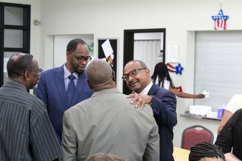 Senior Pastor Rev. Dr. Terrence Moody, right, places his hand on the shoulder of a party guest on Friday, June 21, at the Warrensburg Community Center. Moody has spent 25 years at Shiloh Missionary Baptist Church, where his communal efforts have helped thousands in Warrensburg.