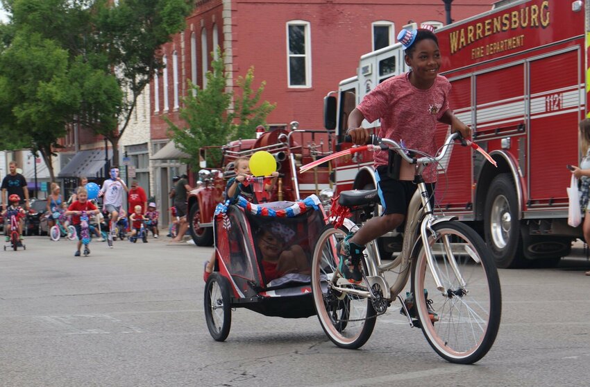 Both passenger and driver are filled with smiles as they ride through downtown Warrensburg during the annual Patriotic Bike Parade hosted by Warrensburg Main Street on Saturday, July 1, 2023.   File photo by Meliyah Venerable | Star-Journal