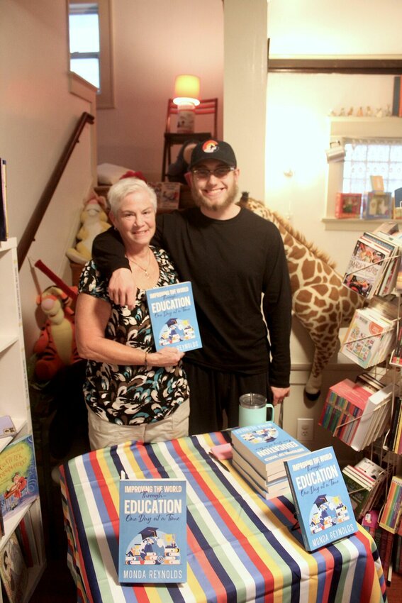 Warrensburg teacher Monda Reynolds, left, poses for a photo with her son Ben and her book “Improving the World Through Education One Day at a Time” that aims to improve education on Saturday, Aug. 24, at the Günzel and Bowser bookstore. 