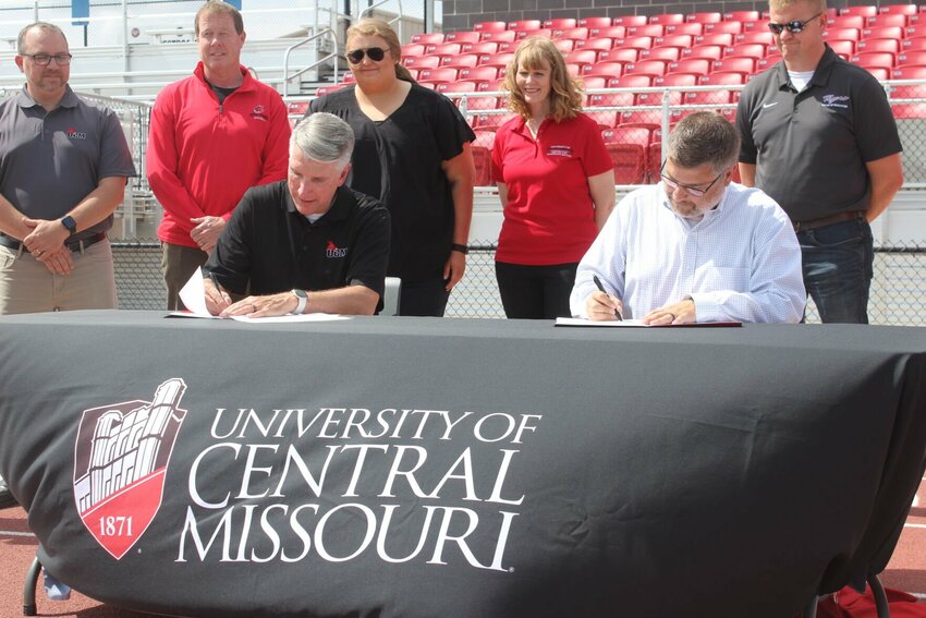 President Best, left, and Superintendent Ritter, right, put pen to paper on the memorandum that will allow UCM and the school district to share facilities free from rental charge on Wednesday, Sept. 18, at the Warrensburg Activities Complex.