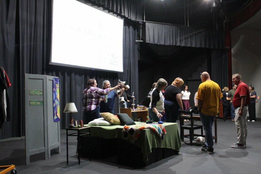 Parents and school staff crowd the auditorium stage fit with a mock teen bedroom, hoping to find devices used to hide substances on Wednesday, Sept. 25, at Warrensburg High School. 