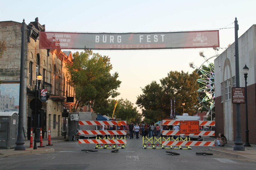 A Burg Fest banner hangs high above the closed-off Holden Street on Friday, Oct. 11, in downtown Warrensburg. The festival's 11th iteration featured carnival rides, live music and over 120 vendors. 