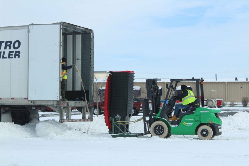 Workers lower 96-gallon trash carts onto the ground on Wednesday, Feb. 19, at Arwood&rsquo;s Furniture &amp;amp; Mattress. The city of Warrensburg and Constable Sanitation, Inc. began deliveries of the carts on Tuesday, Feb. 18.
