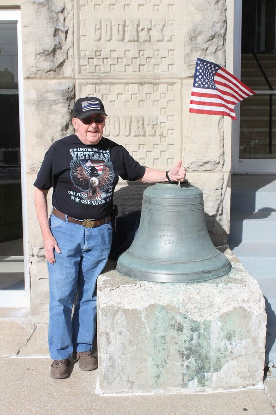 Retired United States Air Force veteran Pete Zwally holds a flag during his protest in support of government on Friday, March 21, at the Johnson County Courthouse.&nbsp;