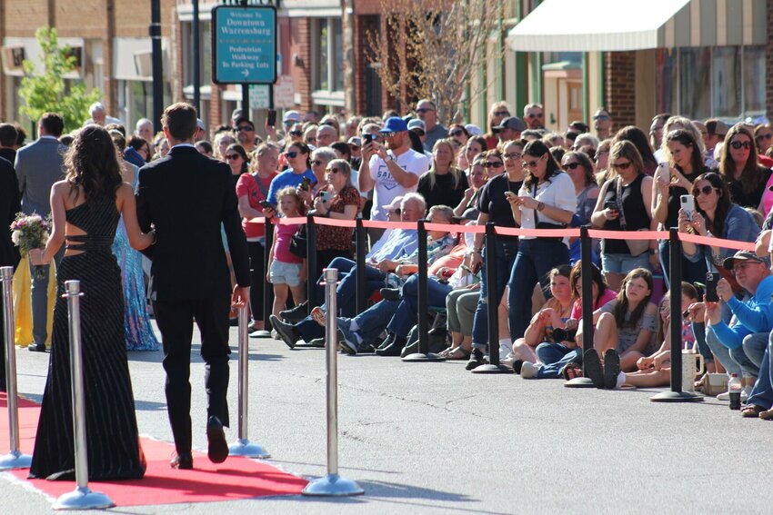 Anxious family members look onto the red carpet for their kids and a good photo opportunity April 13, 2024, during Warrensburg Main Street's fifth annual Prom Parade on Pine Street.