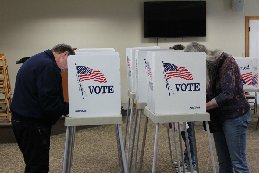 Voters peer into their ballot booths and mark their votes on Tuesday, April 8, at the Grover Park Baptist Church in Warrensburg.&nbsp;