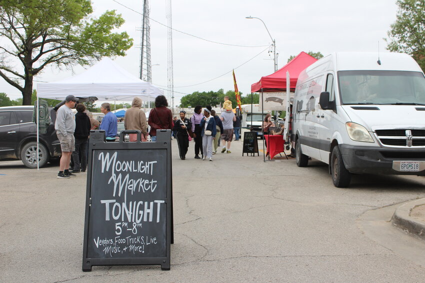 Moonlight Market shoppers walk up and down West Market Street on Saturday, April 24, in downtown Warrensburg. The Moonlight Market served as a precursor to the annual farmer&rsquo;s market, which begins at 8 a.m. on Saturday, May 3.