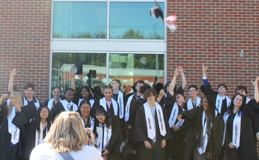 2025 Gateway Educational Center graduates toss their caps in the air for a photo on Thursday, May 15, at the First Baptist Church in Warrensburg.
