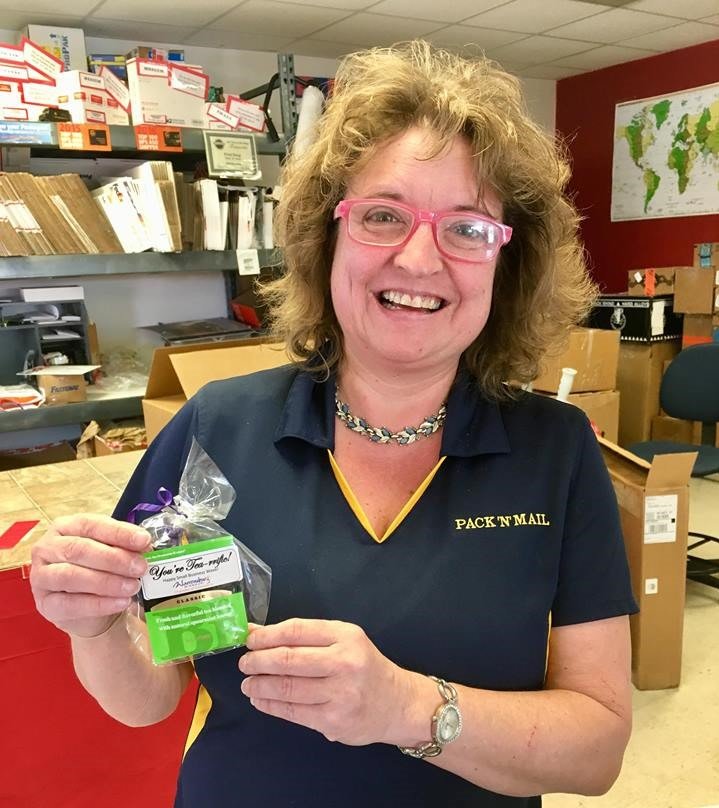 Pack N’ Mail’s Bellinda Laughlin smiles for the camera after receiving a 2018 Small Business Week goodie – a tea bag stating, “You’re Tea-rrific!”.