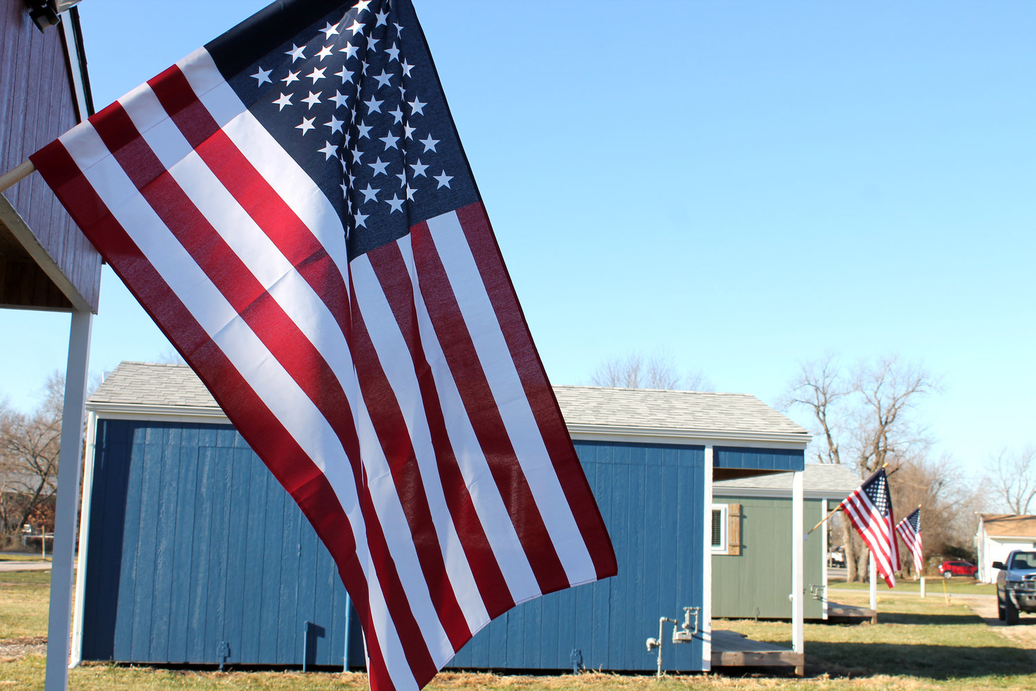 American flags wave in the crisp breeze on the tiny homes in the new Veterans Village on Wednesday morning.