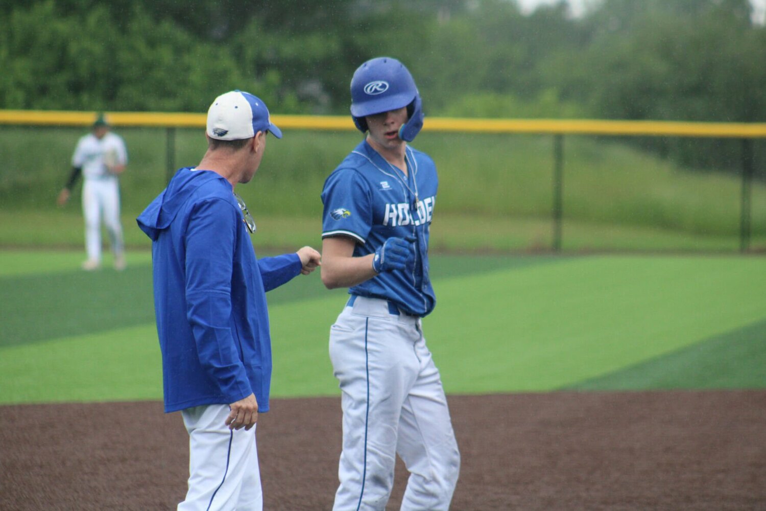 Holden sophoore Justin Brown celebrates a stolen base with head coach Charlie Castle on Monday, May 13, at Holden High School.