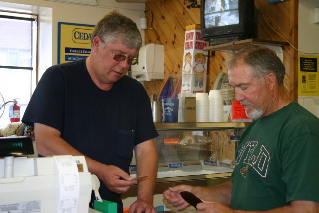 Vermilion Fuel &amp; Food owner Dave Sorensen (left) helps a customer.