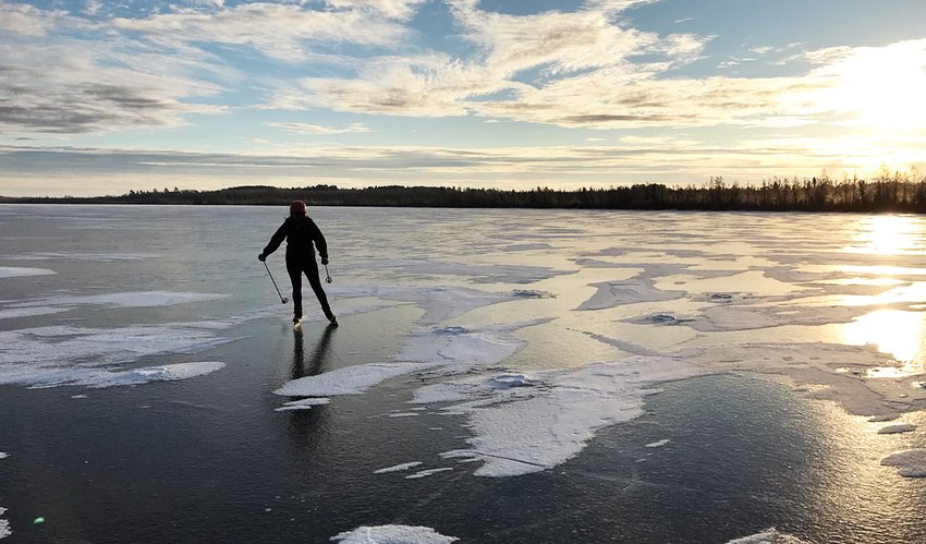 A skater glides across the surface of Lost Lake, near Tower, on a recent late afternoon.  The lake had about nine inches of clear ice as of this week.