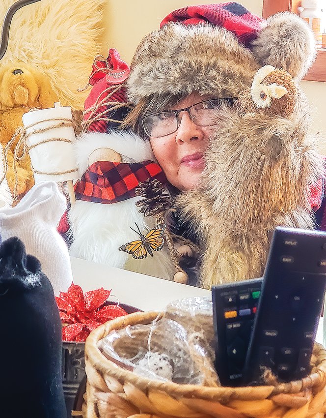 Susan Thomas of Cook holds up two of the many unique gnomes she's created since October.
