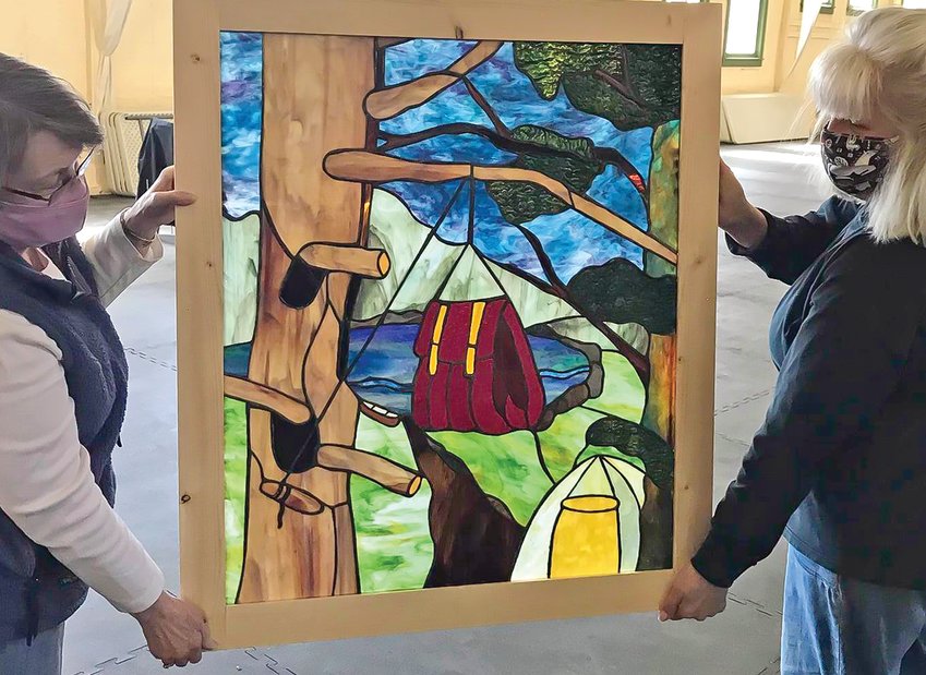 Artists Sandy Bradley and Claire Taylor display one of the windows that&rsquo;s been created for the Ely Public   Library.  All of the windows feature themes from Ely&rsquo;s past and present.