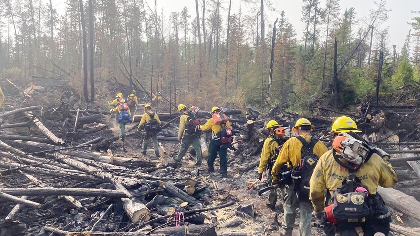A squad of firefighters makes its way along a path cleared through the Delta Lake fire, east of Ely.