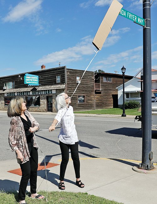 Linda Fryer&rsquo;s sisters, Suzanne Fryer and Gloria Marion remove the cover from the new street sign, highlighting Linda Fryer Way, in Ely.