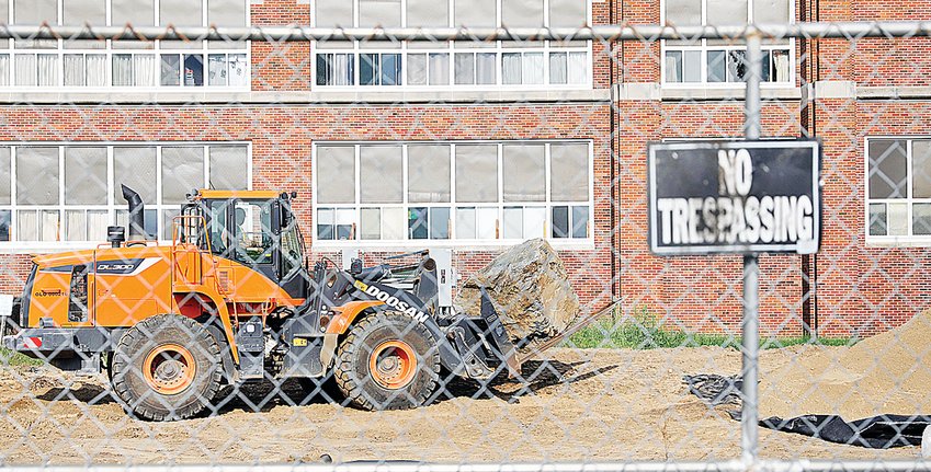 An excavator hauls  rock across the east parking lot on the Ely school campus Tuesday morning as work continues on $21.5 million building and renovation project.