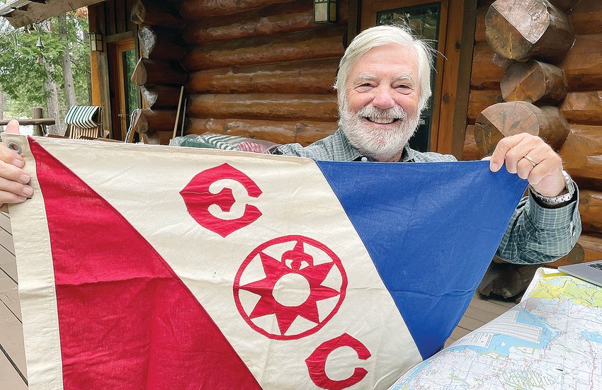 Bill Rom with his   latest Explorer&rsquo;s Club flag in recognition of his recent trip down the Winisk River in northern Ontario, which he completed in July.