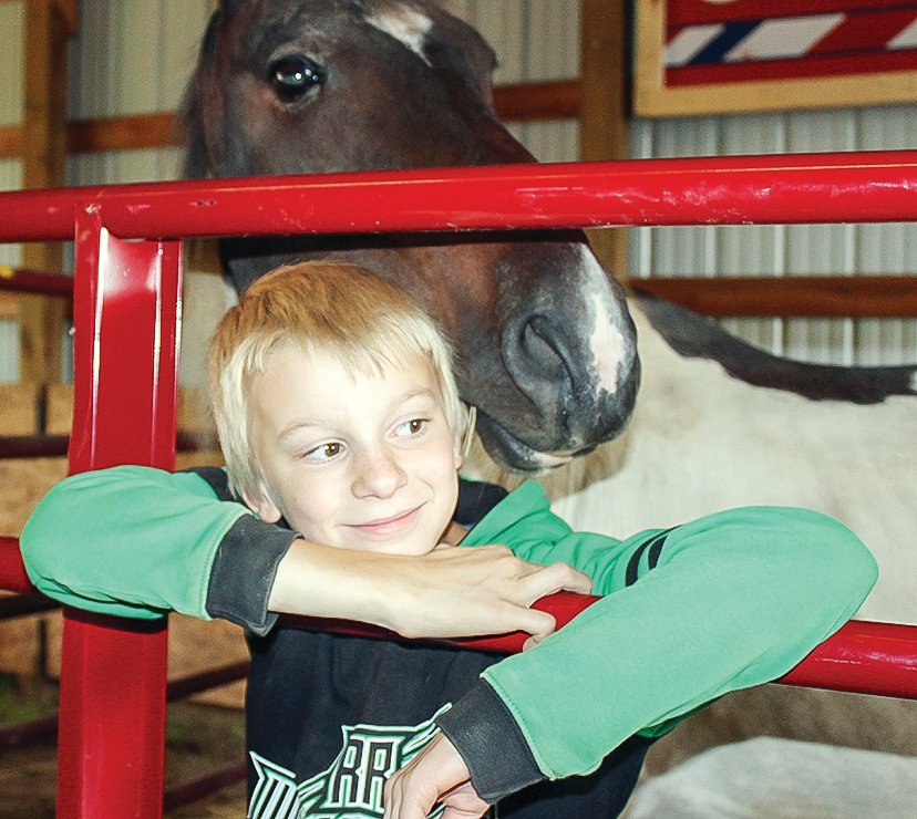 David Elg, of Eveleth, cozies up with Eldy, a horse owned by Shyla Martin, that David has been riding in horse shows this year.