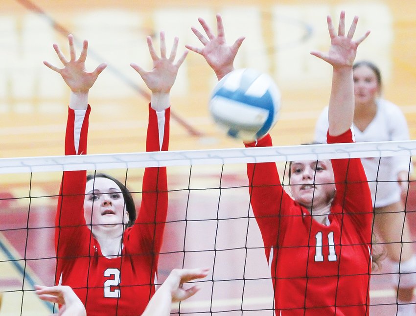 Ely seniors Madeline Kallberg (l) and Rachel Coughlin team up to form a red wall against a Broncos&rsquo; kill attempt.