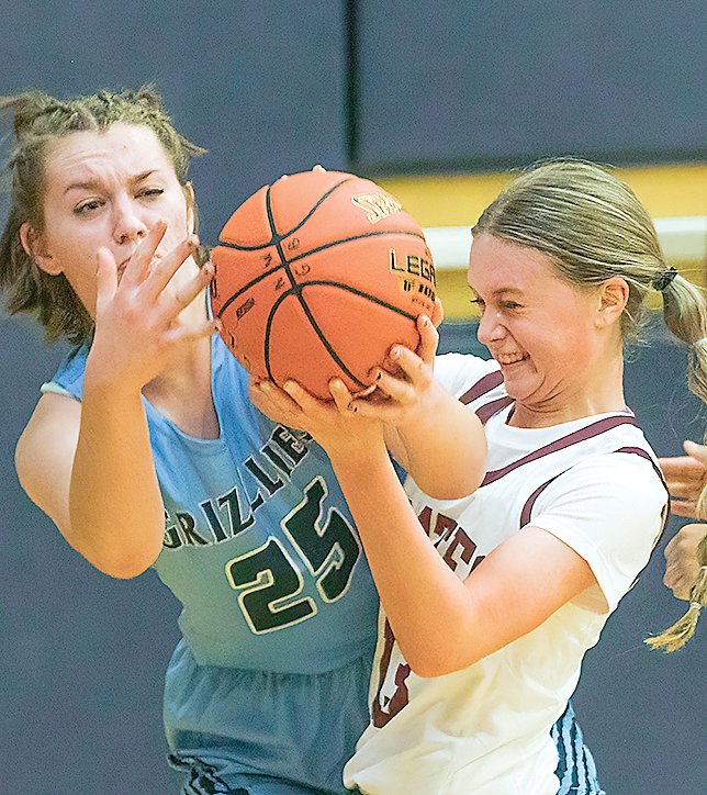 North Woods   junior River Cheney   tangles for the ball with a Two   Harbors player during their Friday night hoops   contest played at North Woods.   The Agates went on to win 83-67.