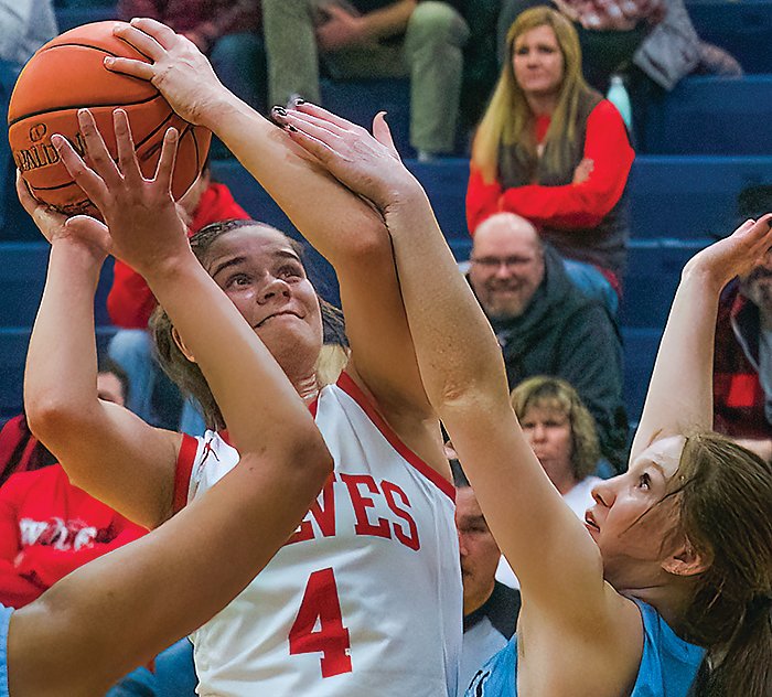 eft: Ely junior Grace LaTourell eyes the bucket while under heavy pressure from North Woods&rsquo; defenders.