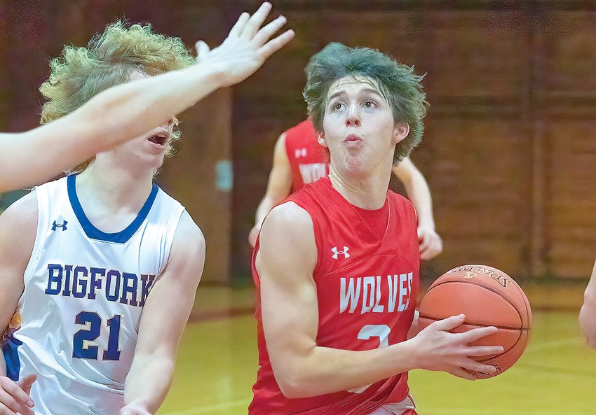Ely senior Joey Bianco eyes the prize while under   pressure from two Bigfork   defenders Tuesday night in Ely.