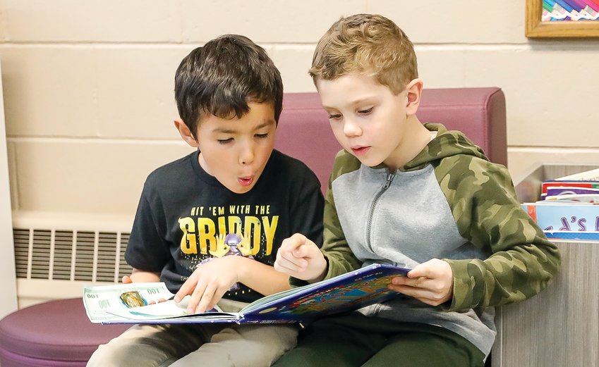Elius Strong and Boone Broten appear fascinated with a book they&rsquo;re reading together.