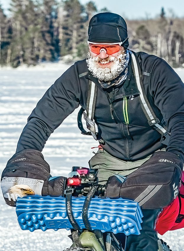 Burnsville bike rider Aaron Olson&rsquo;s   beard is   completely frozen white as he rolls into the checkpoint at Melgeorges on Monday.