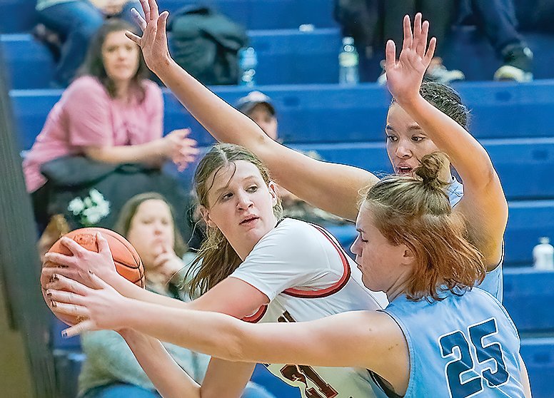 The Grizzlies&rsquo; River Cheney and Hannah Kinsey team up to block out a Mesabi East player on Monday.