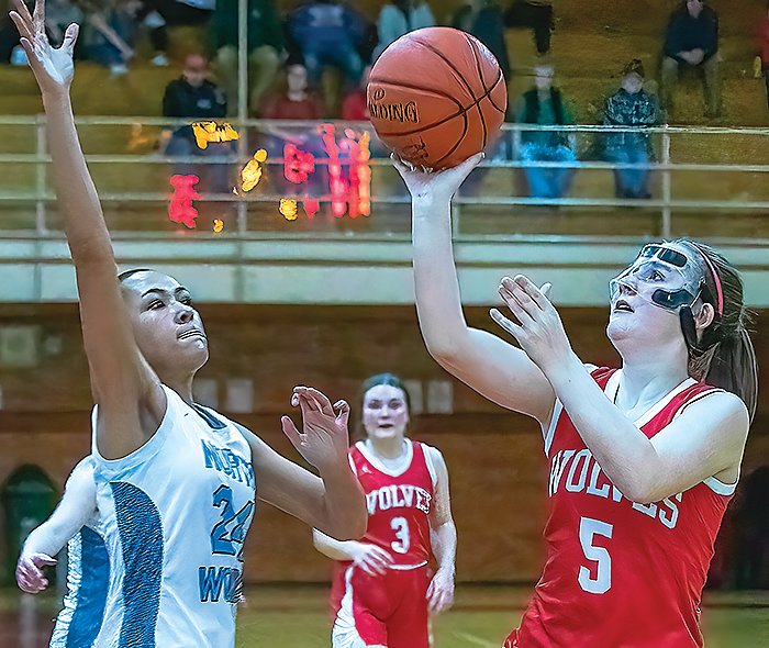 Ely&rsquo;s Zoe Mackenzie goes in for a layup under   pressure from North Woods&rsquo; Kiana LaRoque.