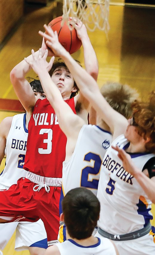 Ely senior Joey Bianco runs into a gauntlet of Bigfork defenders as he goes in for a layup during Ely&rsquo;s opening round playoff tilt with the Bigfork   Huskies.  The Timberwolves went on to win that game 66-39.