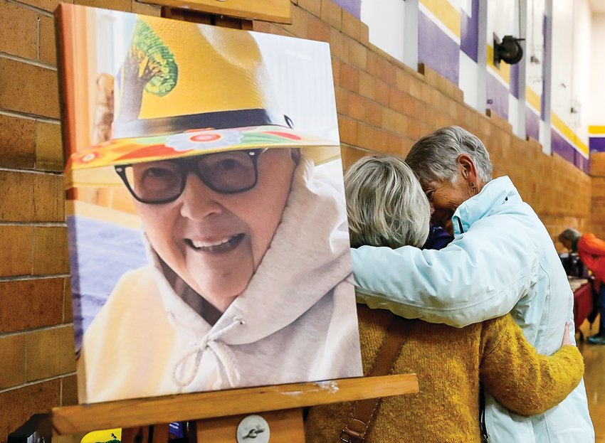 Old friends embrace next to a photo of the late Carol Alstrom, a much loved and respected former   teacher at Tower-Soudan.