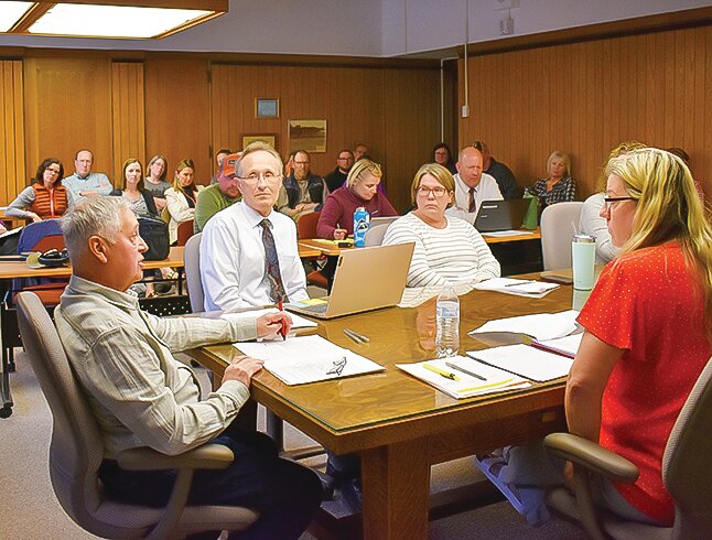 The school board had a full house on May 8 when they voted to approve Anne Oelke as the new school superintendent. Seated at the school board table from left-to-right, Tony Colarich, Tom Omerza, Hollee Coombe, and Rochelle Sjoberg.